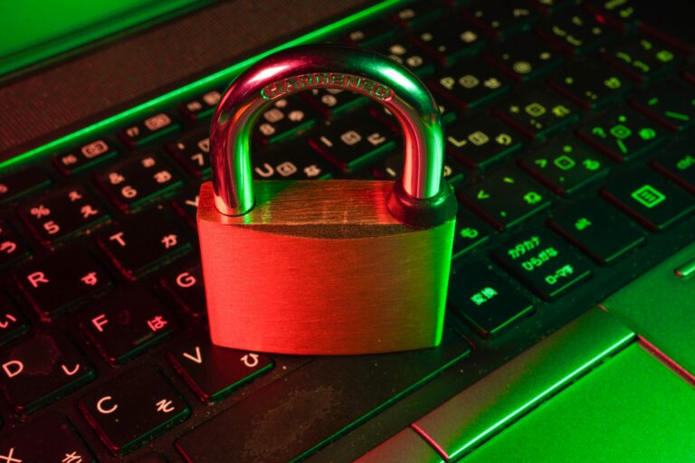 Red padlock resting on a laptop keyboard, representing Microsoft 365 security settings