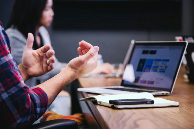 Small business team meeting around a table with laptops