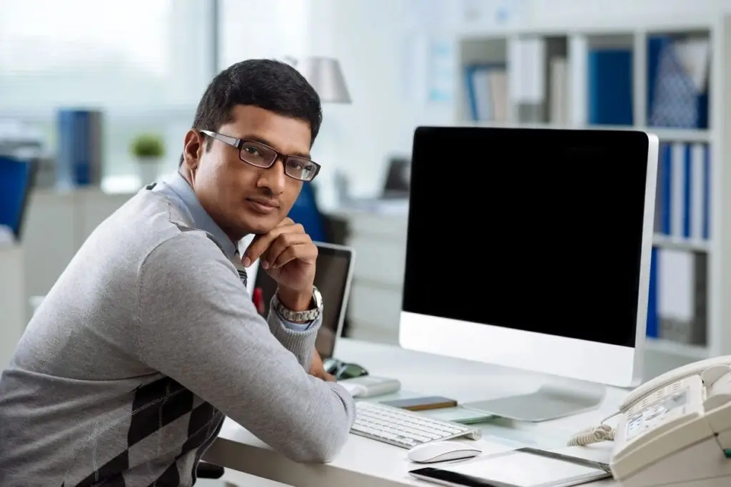 man looking away from mac computer