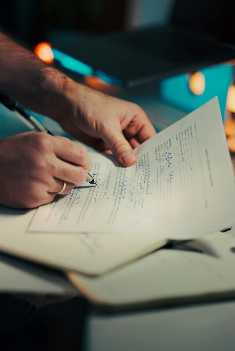 A business owner signing an insurance policy document, representing cyber insurance requirements for small business in NC | Credit: Photo by Jakub Zerdzicki on Unsplash